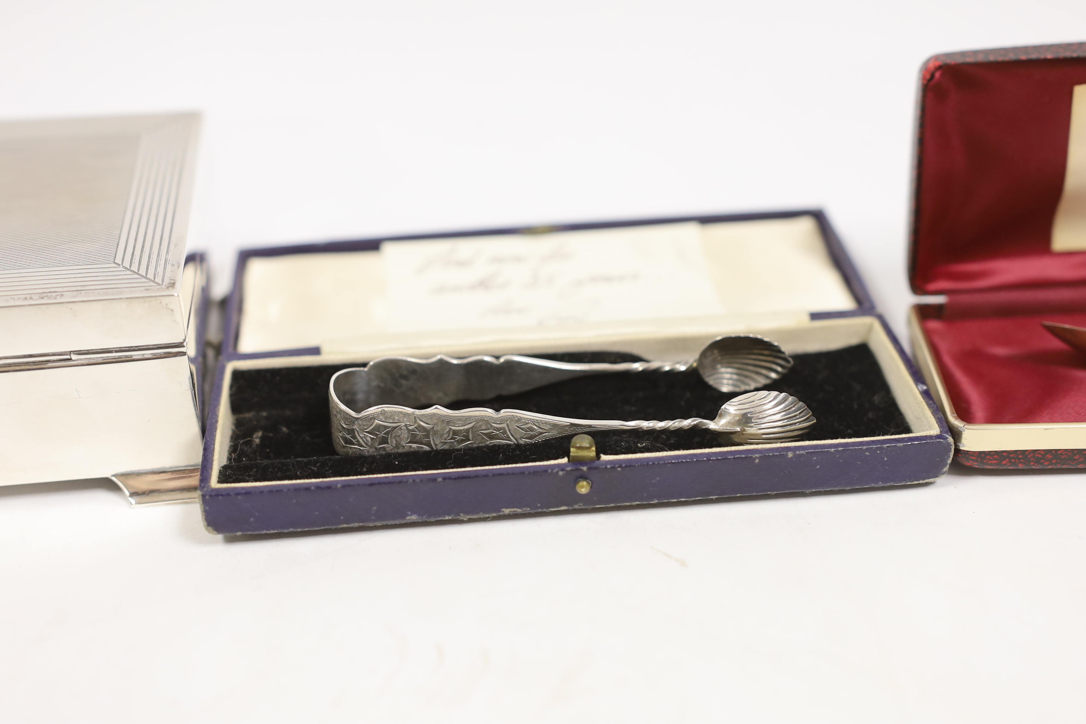 An Elizabeth II silver mounted rectangular cigarette box, Birmingham, 1963, 17.4cm, a cased 1920's silver mounted ebonised conductor's baton, 52.5cm, a pair of silver sugar tongs and a small silver spoon.